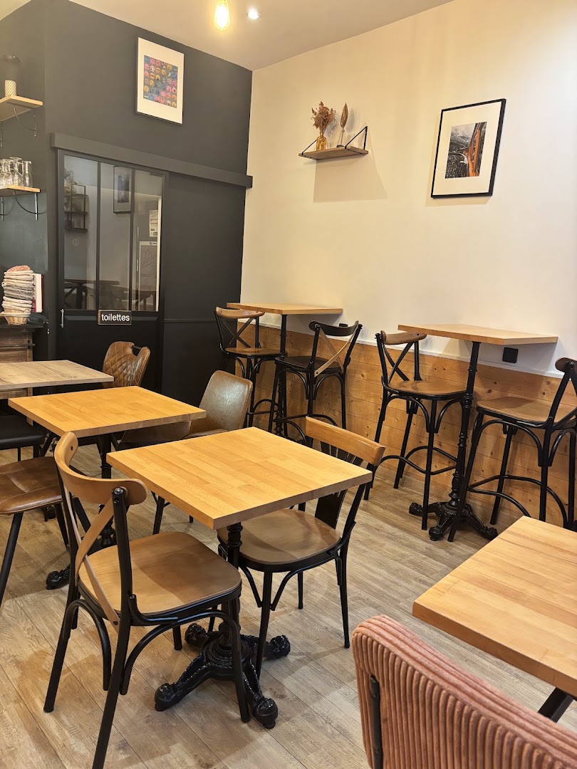 Un coin de la salle du café aménagé de petites tables