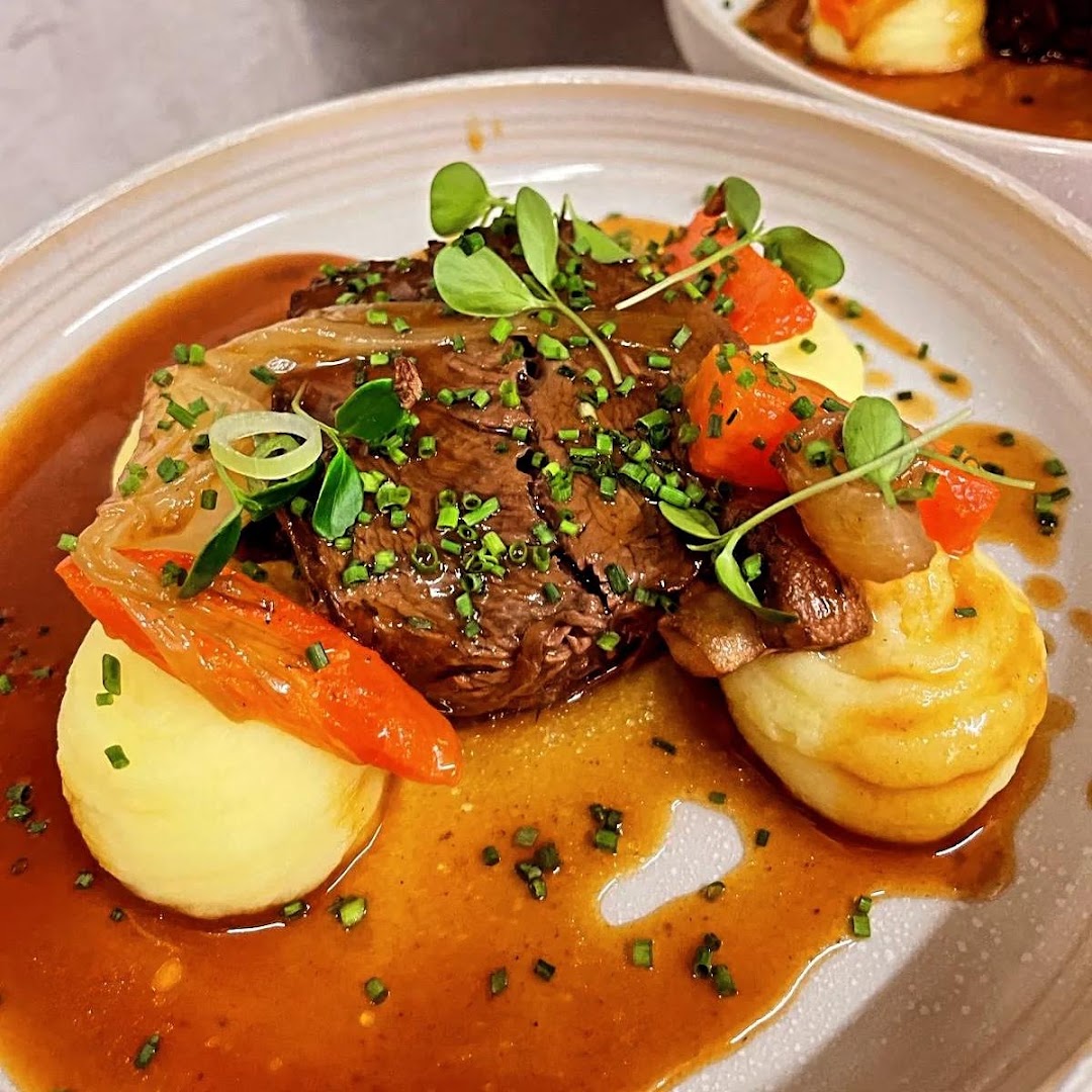 Une assiette servie avec purée, légumes et sauce